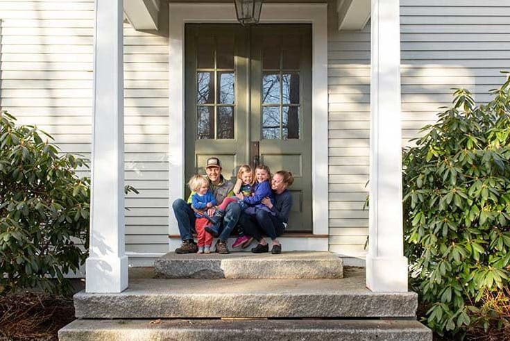 family laughing, posed on stone steps