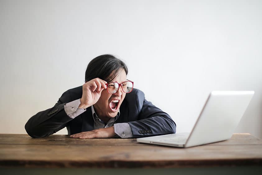 man looking at laptop in surprise