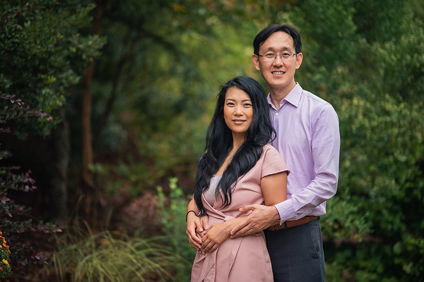 Image of an Asian man embracing an Asian woman from behind. Photo by Kazka Photography