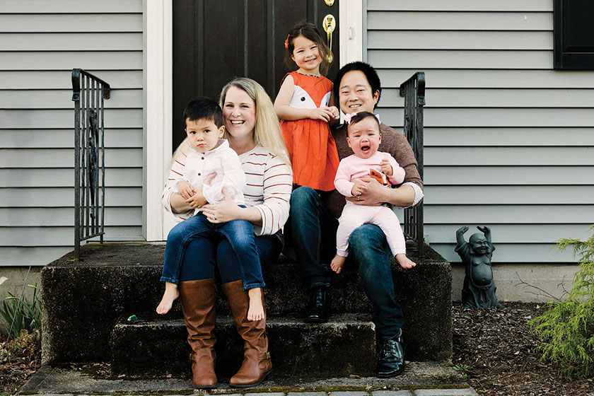 family posed sitting on cement steps