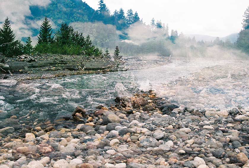 double exposure of rocky river and clouds