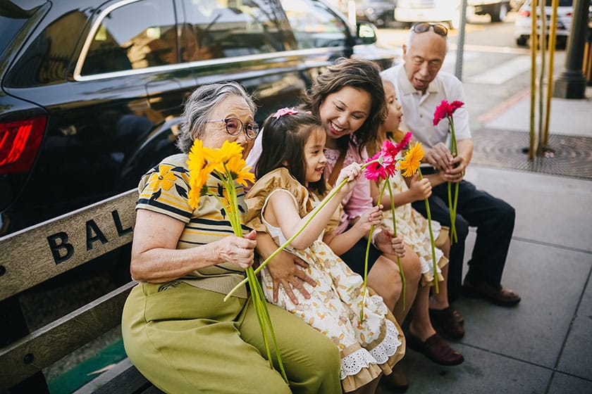 multi-generation asian family sitting on bench