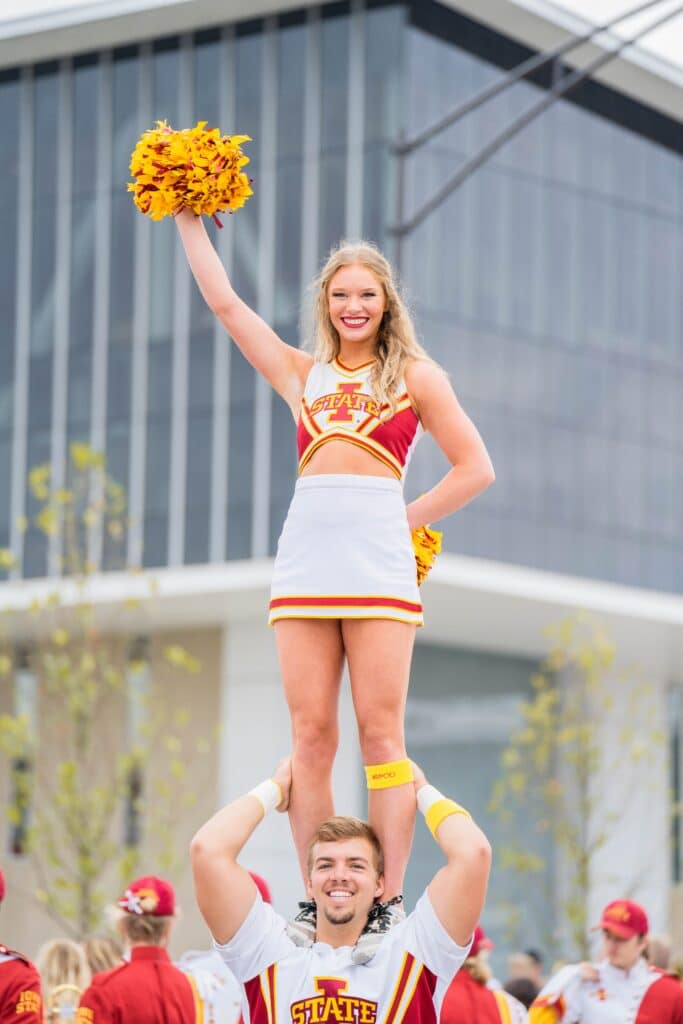 female cheerleader on male cheerleader's shoulders