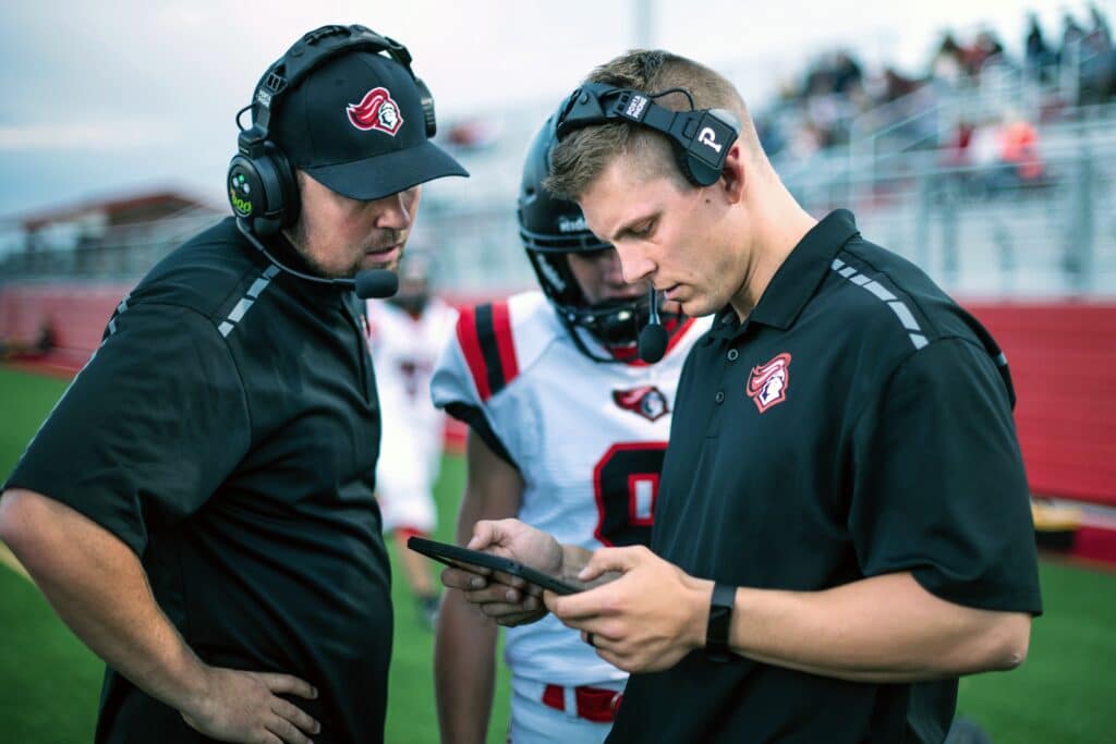 football coaches conferring on plays