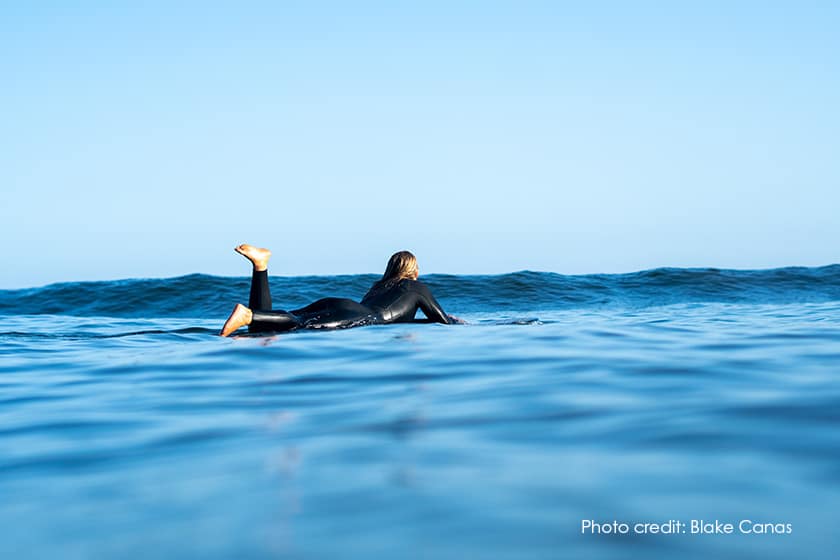 surfer paddling out to wave