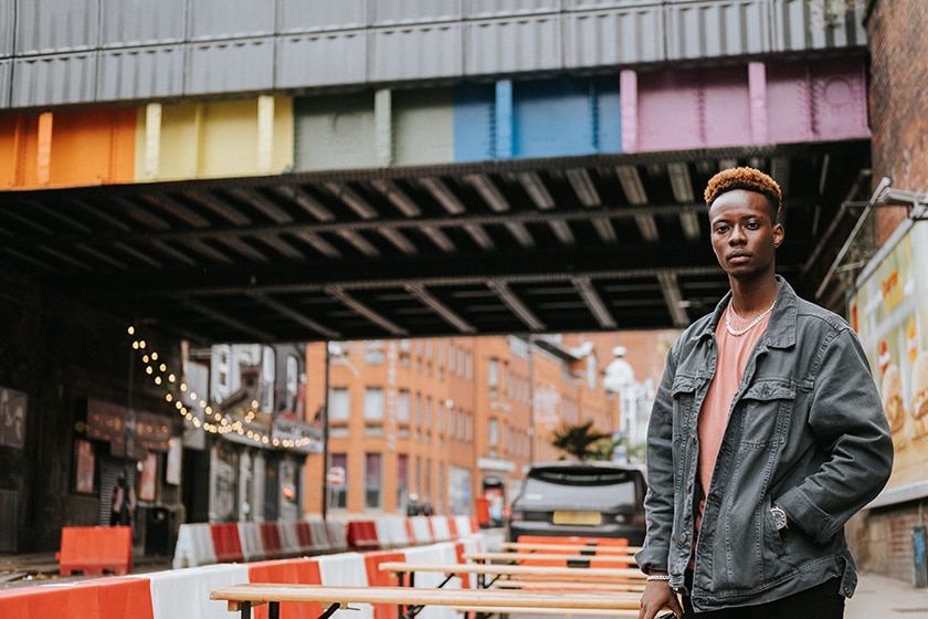 man in city with rainbow bridge in background