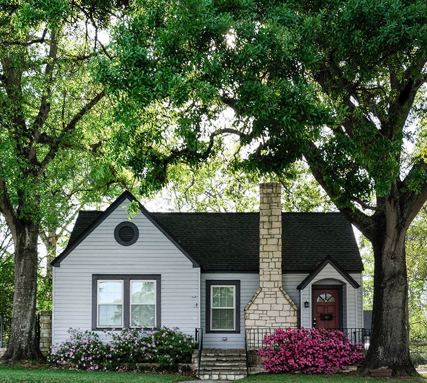 cute white house with green trees