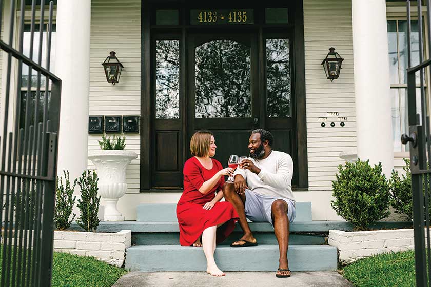 couple toasting wine glasses while sitting on porch steps