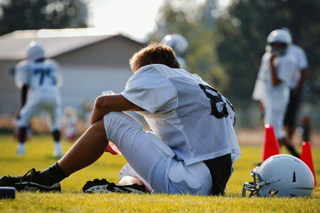 kid on sidelines during football practice