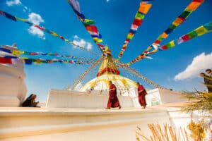 Laura Grier monks walking under color flags