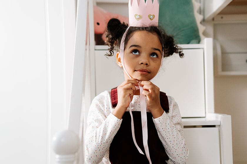 child wearing DIY paper and glitter crown