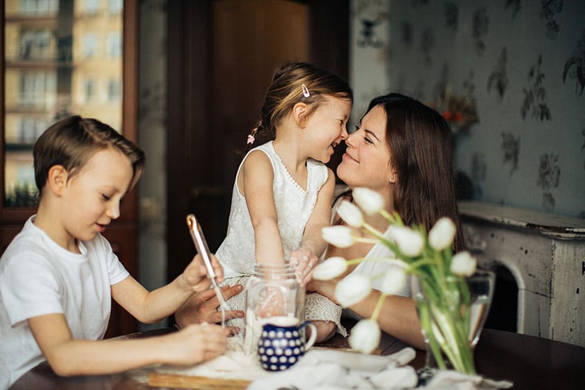 mother with children and rubbing noses with daughter