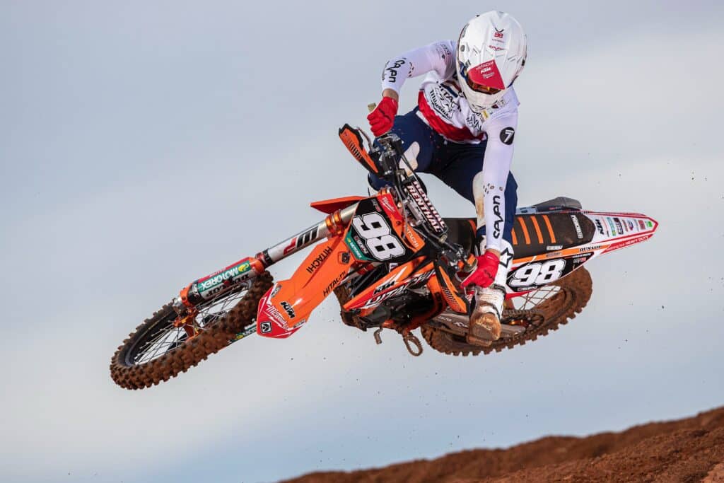 man in red and white motocross helmet riding motocross dirt bike