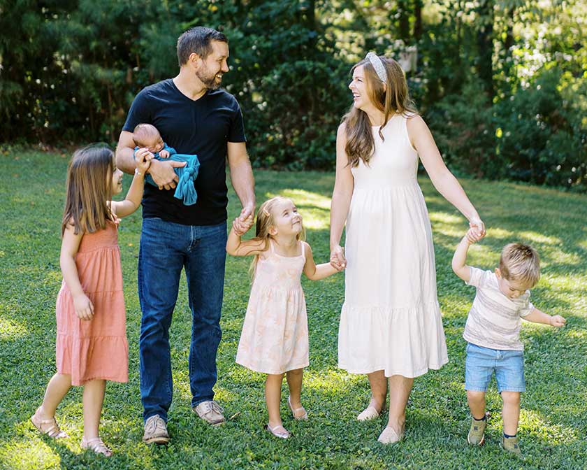 family of five holding hands outdoors