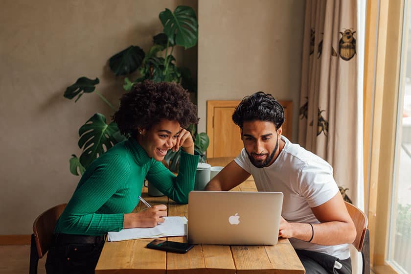 woman and man smiling at computer