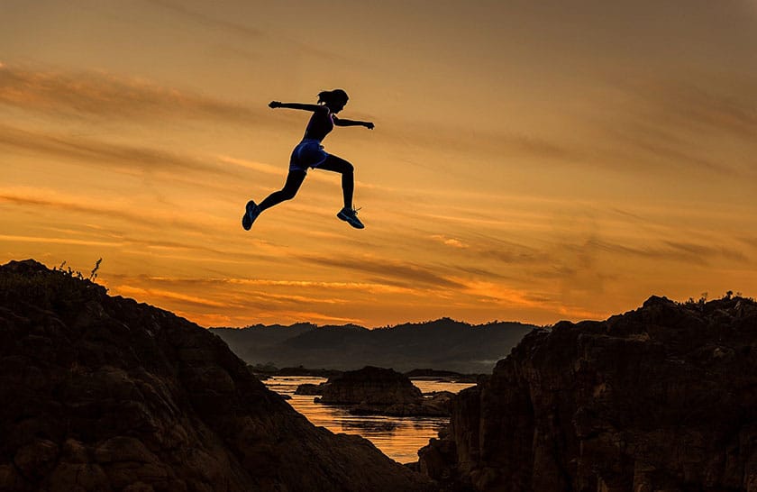 runner leaping across divide