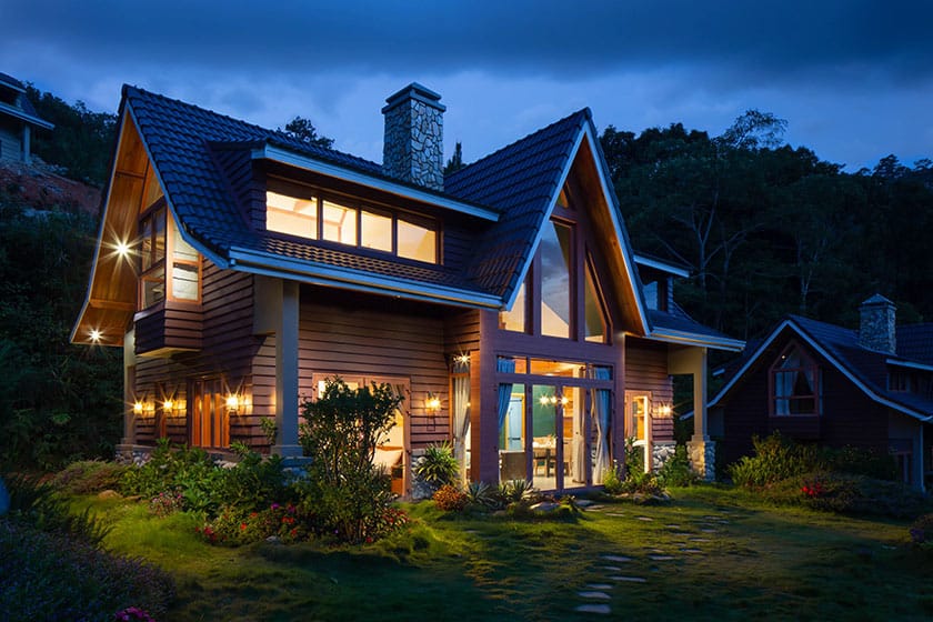 a-frame home with lights on at night