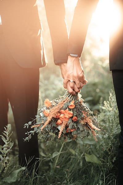 grooms holding hands at wedding