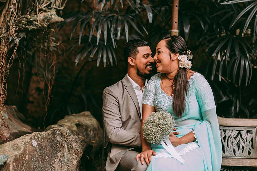 bride cuddled onto groom's lap and holding her bouquet