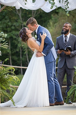 bride and groom kissing at altar