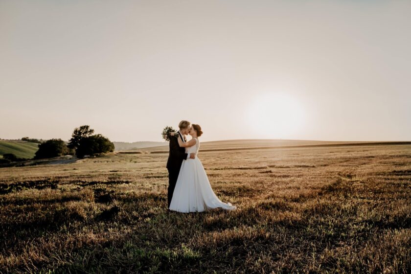 wedding couple portrait in a grassy field near sunset