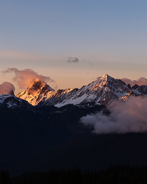 landscape photograph of snow dusted mountains in golden sunrise light