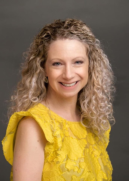 headshot of woman wearing yellow shirt