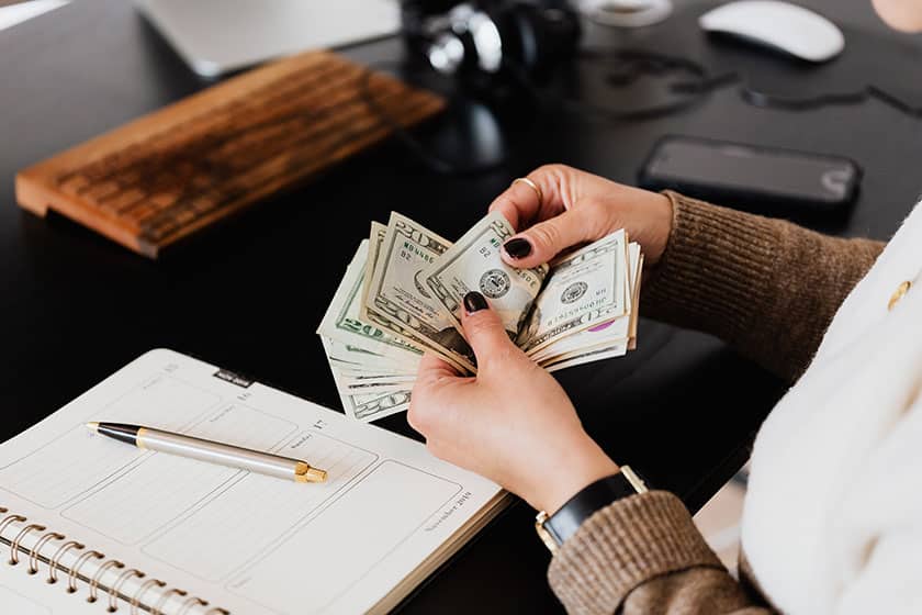 hands counting cash at desk